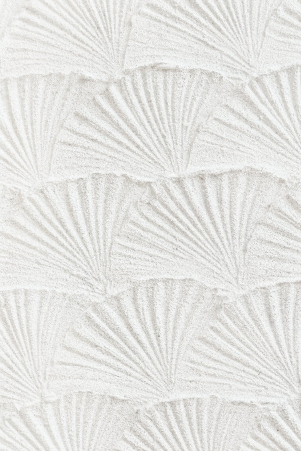 White textured wall panel with a repeating embossed fan or scallop pattern.